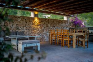 a patio with a table and chairs and a stone wall at Sa Lluna in Sant Josep
