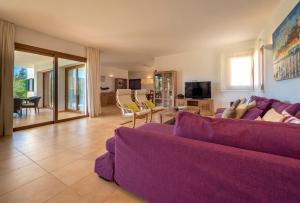 a living room with a purple couch and a tv at Sa Lluna in Sant Josep