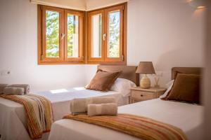 two beds in a room with two windows at Sa Lluna in Sant Josep +68 photos