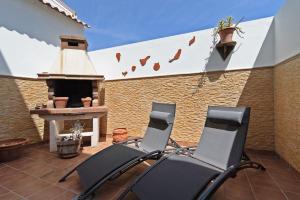 two chairs sitting on a patio with a fireplace at Casa La Herradura in Telde
