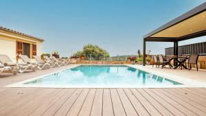 a swimming pool on a wooden deck with chairs around it at Moli De Can Cristan in Muro