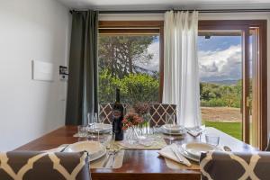 a dining room table with a bottle of wine and a window at Bellavista Cottage in Barberino di Mugello