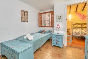 a bedroom with a bed and a table and a window at Casa Oliana in Cómpeta +29 photos