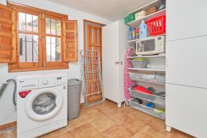 a laundry room with a washing machine and a refrigerator at Casa Oliana in Cómpeta
