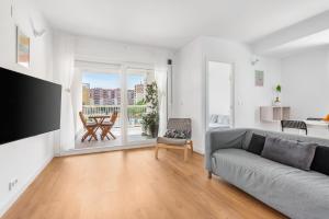a living room with a gray couch and a balcony at Lopimar Playa in Canet de Berenguer