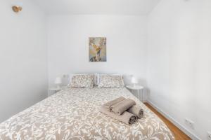 a white bedroom with a bed with towels on it at Lopimar Playa in Canet de Berenguer +21 photos