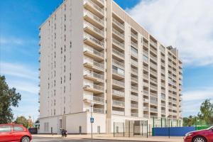 an apartment building on a street with cars parked in front at Lopimar Playa in Canet de Berenguer