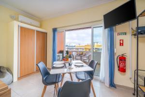 a dining room with a table and chairs and a window at Aqua Studio in Portimão