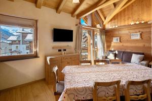 a bedroom with a bed and a tv and a window at Livigno Wooden House in Livigno
