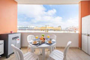 a dining room with a table and chairs on a balcony at Aqua Studio in Portimão