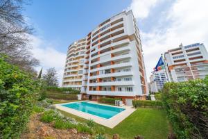 an apartment with a swimming pool in front of a building at Aqua Studio in Portimão