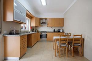 a kitchen with wooden cabinets and a table and chairs at A O - Tina House Ferrel in Ferrel +11 photos