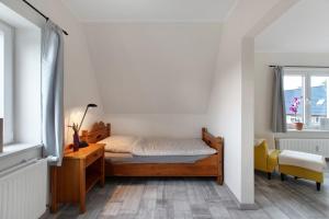 a bedroom with a bed and a desk and a window at Ferienwohnung Janina in Norddeich