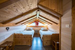 a room with two beds in a log cabin at Chalet La Petite Maison in Saint-Marcel