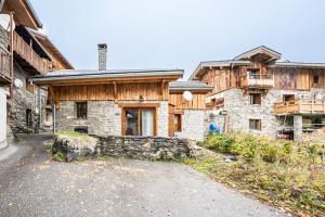 an old stone house with a stone driveway at Chalet La Petite Maison in Saint-Marcel