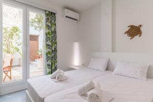 a white bedroom with a bed with towels on it at A Tinian Room 3 in Tinos