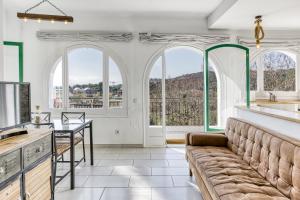 a kitchen with a couch and a table and windows at Masia Cal Ros in S'agaro