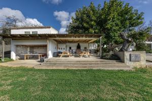 a pavilion with a picnic table and a tree at Masia Cal Ros in S'agaro