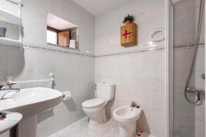 ein weißes Badezimmer mit Toilette und Waschbecken in der Unterkunft Lorences B in Caunedo + 17 Fotos