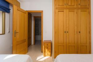 a bedroom with two beds and a hallway with two doors at Jardín X in Gandía +14 photos