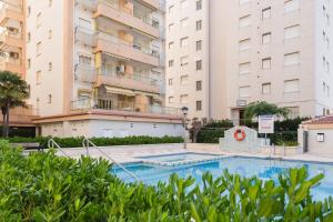 a swimming pool in front of two tall buildings at Jardín X in Gandía