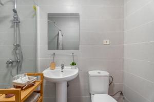 a bathroom with a white toilet and a sink at Sunset Lux Las Floritas in Arona