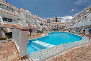 a swimming pool in front of a apartment building at Sunset Lux Las Floritas in Arona +20 photos