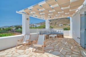 a patio with chairs and a table on a balcony at Villa Afroditi A in Antiparos