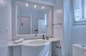 a white bathroom with a sink and a mirror at Villa Afroditi A in Antiparos +24 photos