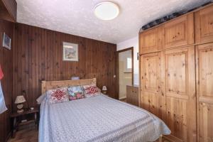 a bedroom with a bed with wood paneled walls at Les Rocailles in Notre-Dame-de-Bellecombe