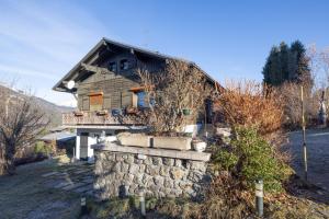 a house with a stone retaining wall and a house at Les Rocailles in Notre-Dame-de-Bellecombe