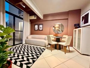 a living room with a couch and a table and chairs at Central Duplex Loft Near USP in São Carlos