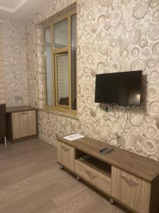 a living room with a flat screen tv on a wall at Cirag Hotel Kurdemir in Kyurdamir
