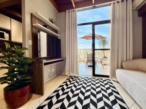 a living room with a view of a patio at Central Duplex Loft Near USP in São Carlos