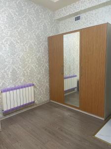 an empty room with a mirror and a wooden cabinet at Cirag Hotel Kurdemir in Kyurdamir