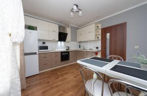 a kitchen with white appliances and a table with chairs at Apartment near VDNG 18010 in Kyiv