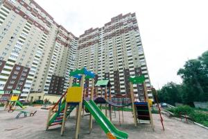 a playground in front of a large apartment building at Apartment near VDNG 18010 in Kyiv