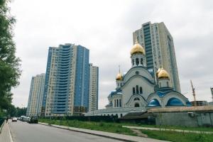 a building with gold domes on top of it next to tall buildings at Apartment near VDNG 18010 in Kyiv