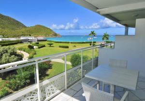 a balcony with a table and a view of the ocean at Le Domaine Anse Marcel Beach Resort in Anse Marcel 