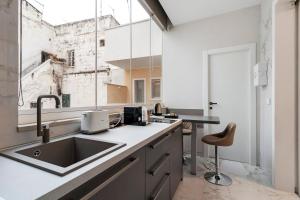 an industrial kitchen with a sink and a window at Ginex Luxury Suite, Trani in Trani