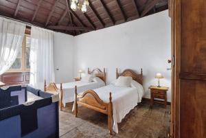 a bedroom with two beds and a window at Casa Rural El Palmar in Vallehermoso