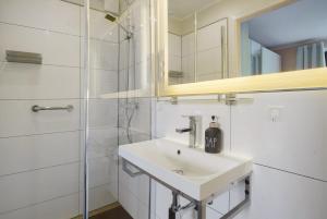 a white bathroom with a sink and a mirror at Ferienwohnung Sonnenblick in Putbus +29 photos
