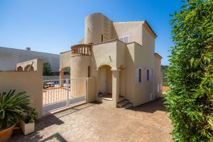 a house with a turret on the side of it at Villa Sion in Cala Mendia