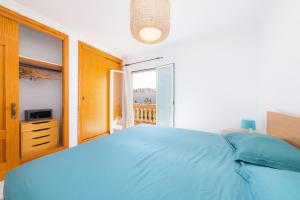 a bedroom with a blue bed and a balcony at Villa Sion in Cala Mendia +23 photos
