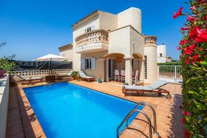 a villa with a swimming pool in front of a house at Villa Sion in Cala Mendia