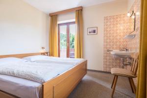 a bedroom with a bed and a sink and a bathroom at Ferienwohnung 3 Vikoler in Vols am Schlern