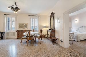 a dining room with a table and chairs and a bedroom at Biennale Apartment near San Marco in Venice