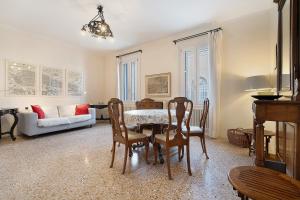 a living room with a table and chairs and a couch at Biennale Apartment near San Marco in Venice +20 photos