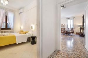 a bedroom with a bed and a dining room at Biennale Apartment near San Marco in Venice