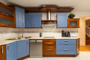 a kitchen with blue cabinets and a sink at Villa La Perla De Sonabia in Oriñón